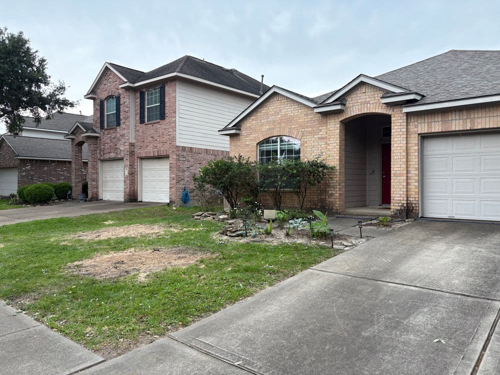 Two neighboring houses with brick and siding exteriors, driveways, and landscaped yards.